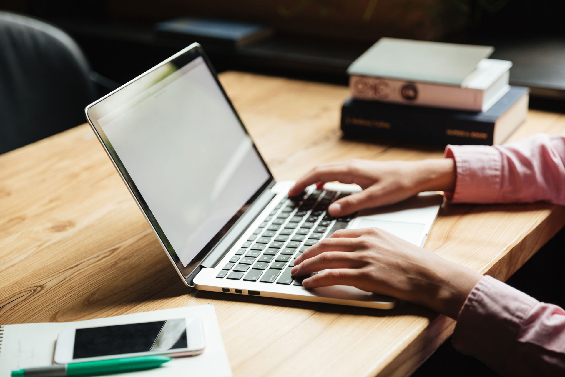 Eine Person arbeitet an einem Laptop auf einem Schreibtisch – Symbolmotiv für die Nutzung von Online-Services am Computer.