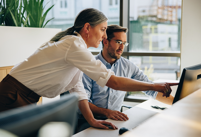 startseite-interaktion Zwei Personen arbeiten gemeinsam an einem Laptop – Symbolmotiv für persönliche Beratung und Unterstützung bei digitalen Aufgaben.